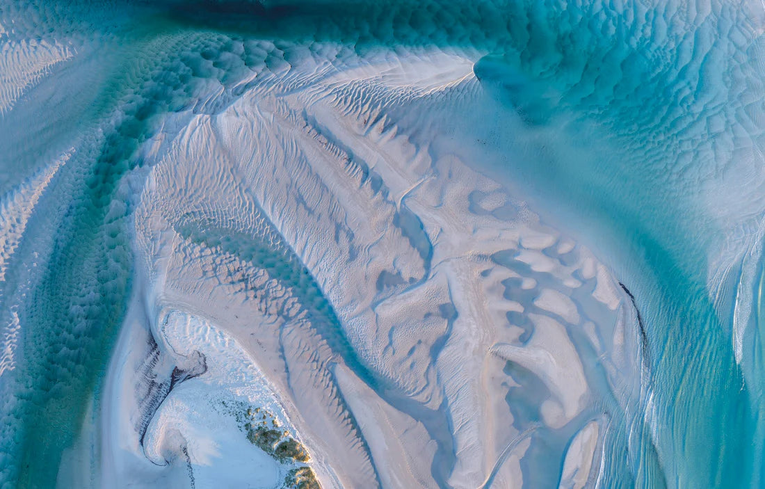 Aerial view of a winding turquoise river or estuary flowing through pale sandbars and shallow white water, creating an abstract natural pattern. - Rob Blakers Tasmanian Landscapes Calendar