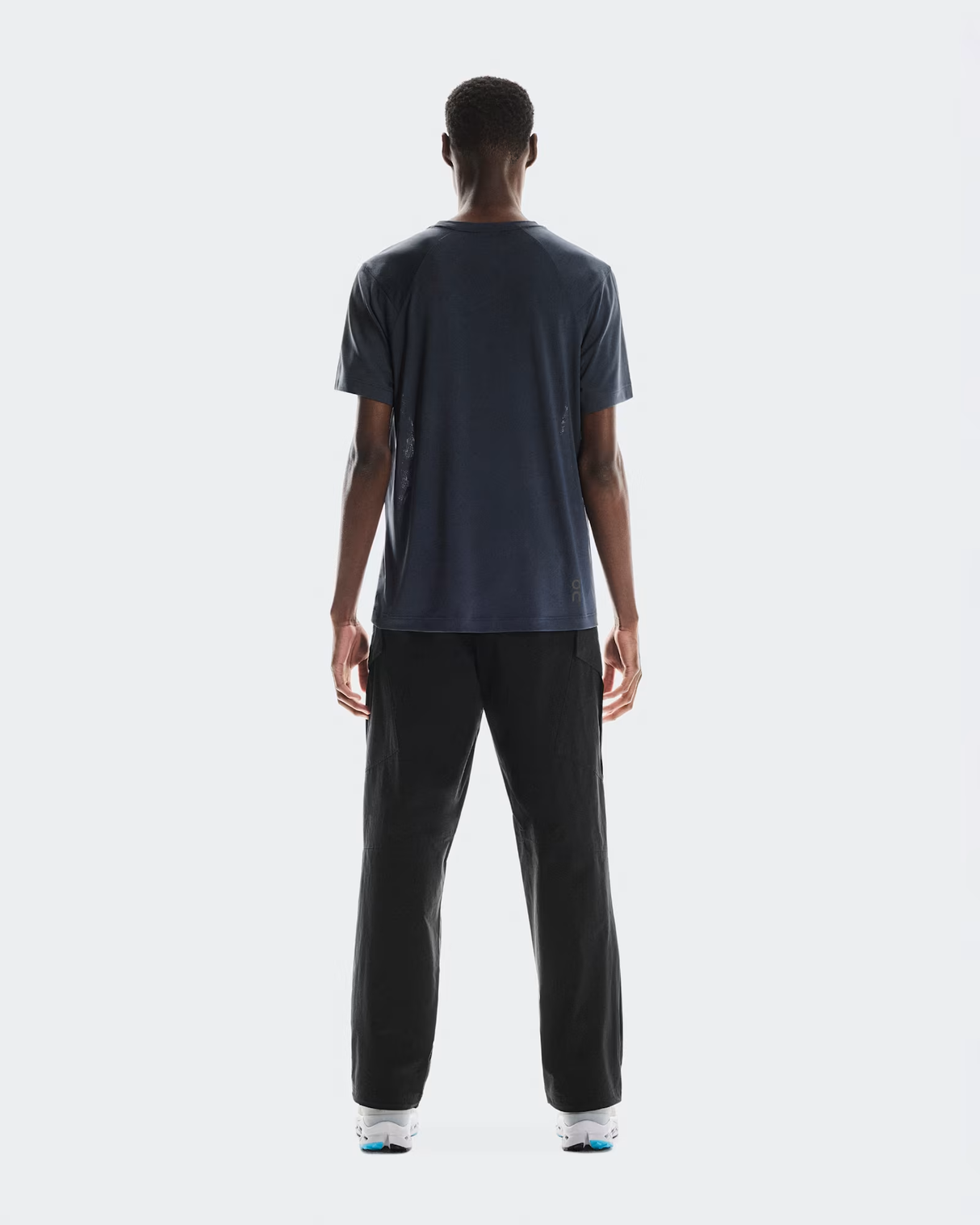 Person wearing a dark gray t-shirt and black pants on a white - On Trail-T (Men's) - Navybackground