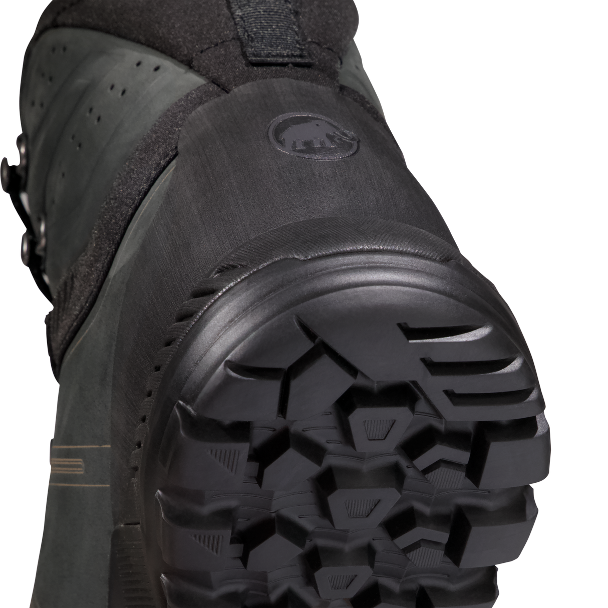 Close-up detail shot of the outsole and heel area of a black snowboard boot, showing the tread pattern and a circular logo embossed on the heel counter. - Mammut Mercury Tour II High GORE-TEX (Men's) - Black/Black