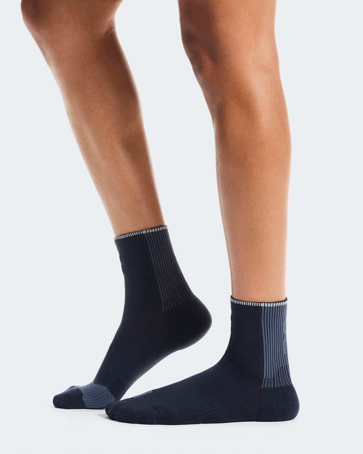 Navy socks worn by a person on a light gray background - On Performance Run Sock Mid (Unisex) - Navy/Navy