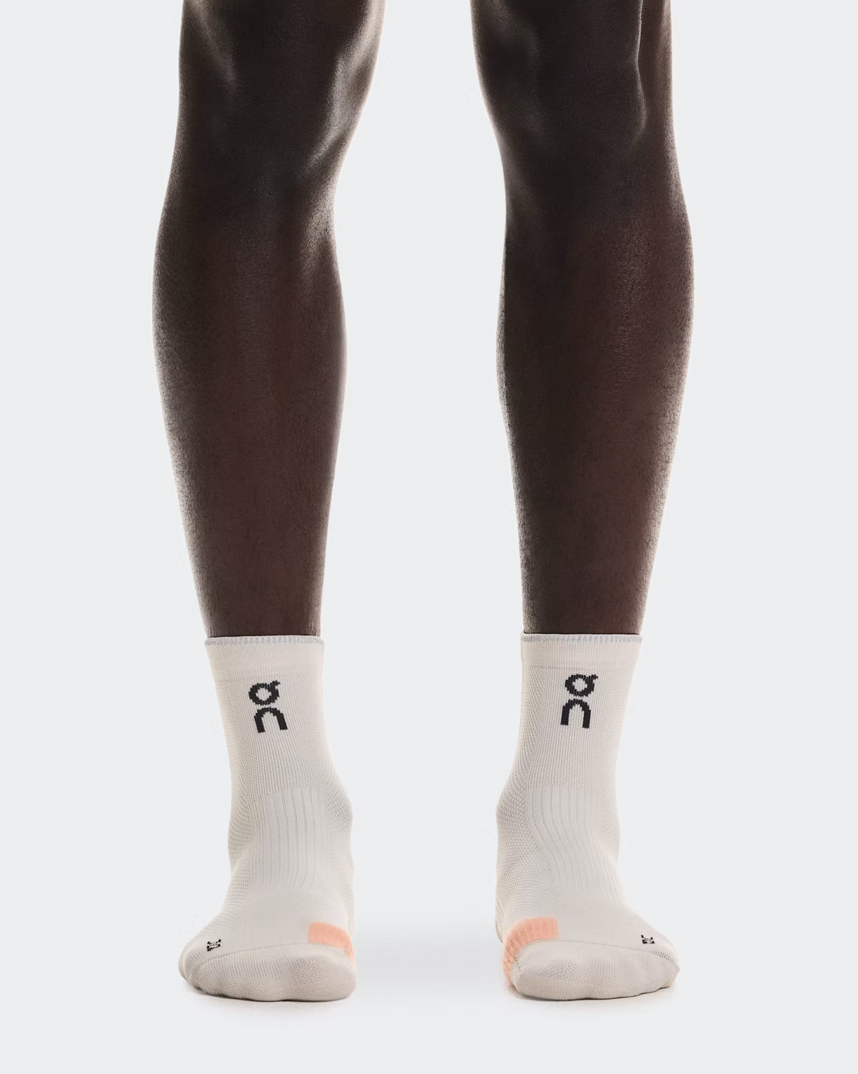White socks with a logo worn by a person on a white background - On Performance Run Sock Mid (Unisex) - Pearl/Sunstone