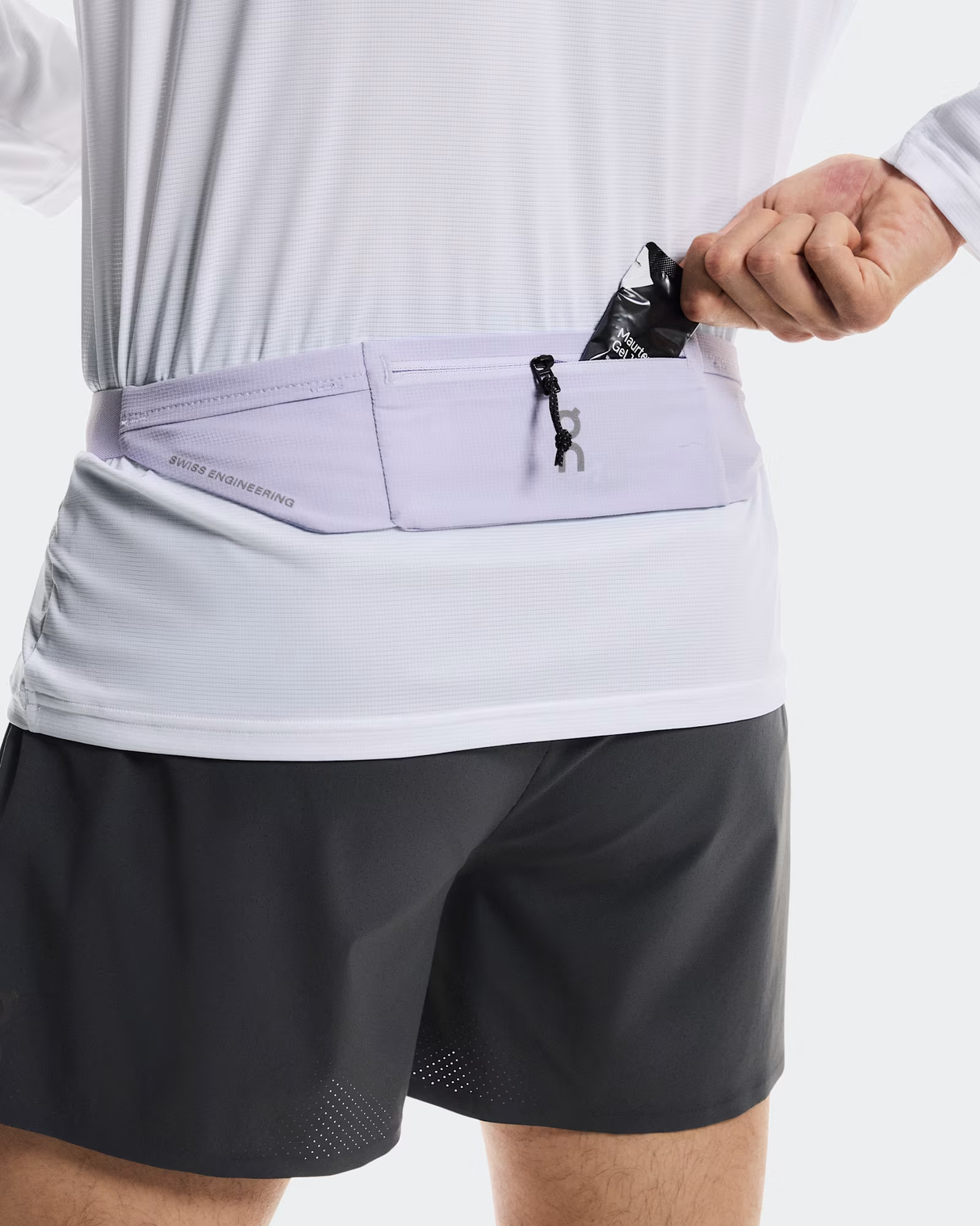 Person wearing a light purple running belt with a white shirt and black shorts on a plain background - On Speed Belt (Unisex) - Thistle
