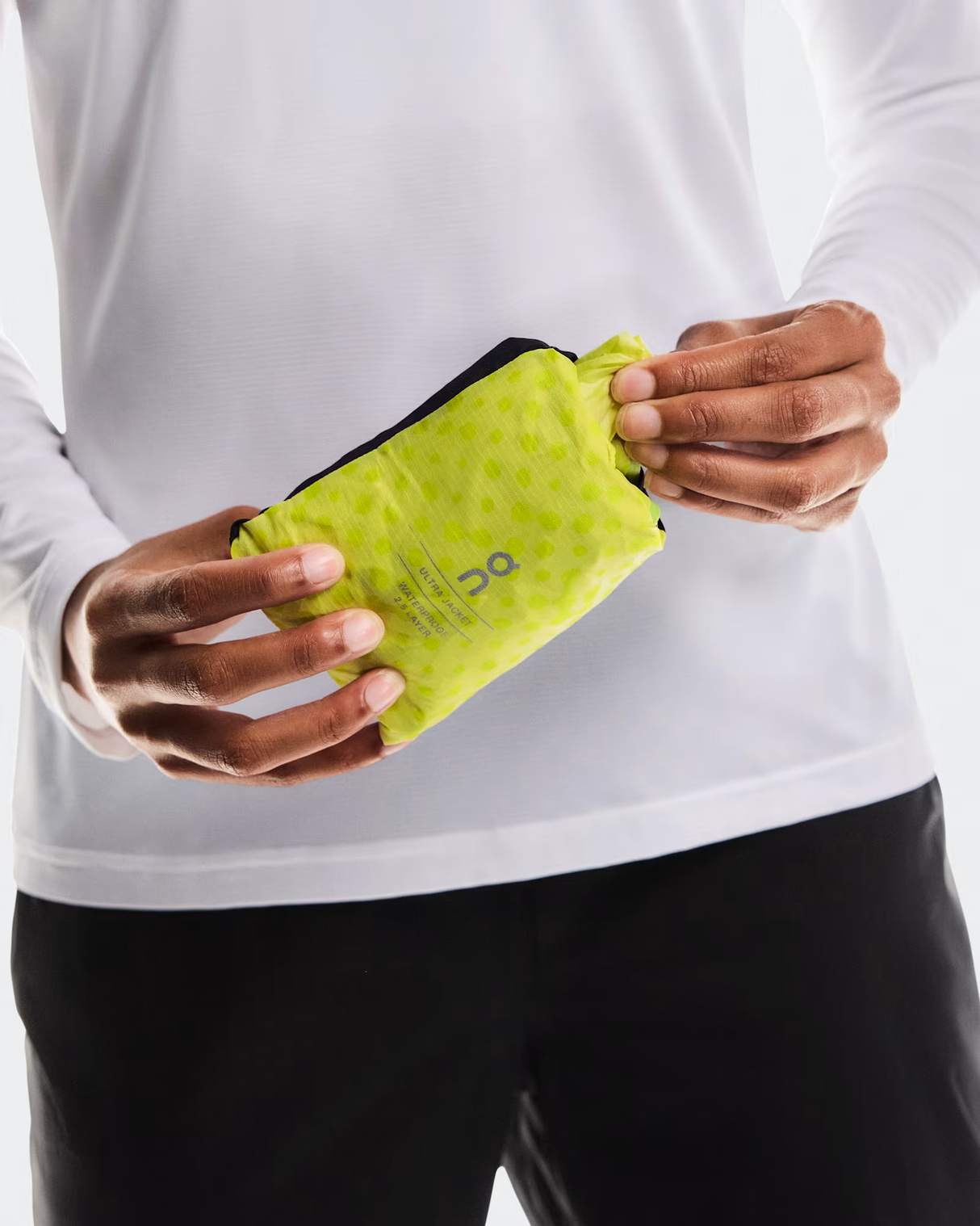 Person holding a green sweatband with a brand logo on a white - On Ultra Jacket (Women's) - Limelight/Limebackground