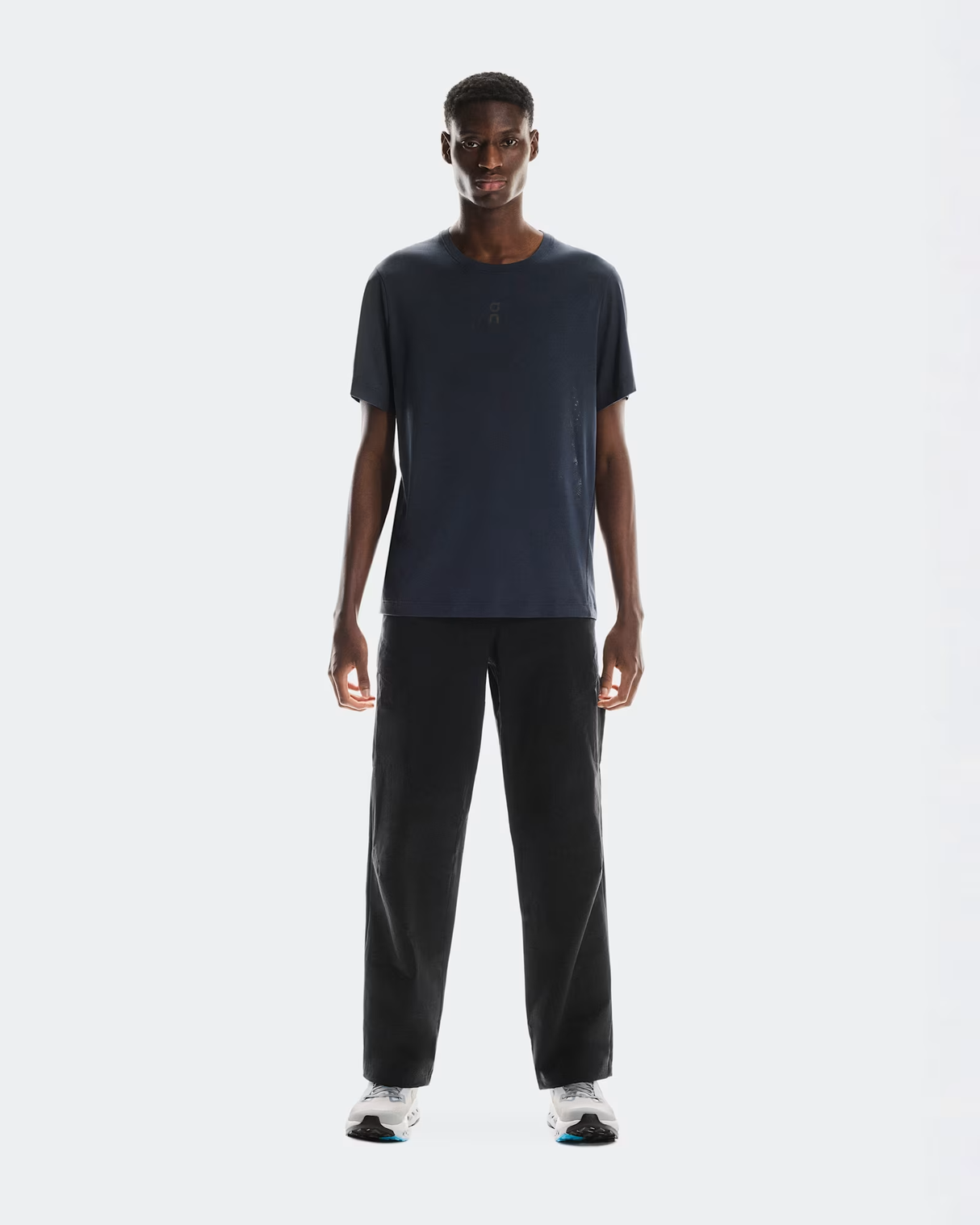 Man wearing a dark blue t-shirt and black pants on a white background - On Trail-T (Men's) - Navy