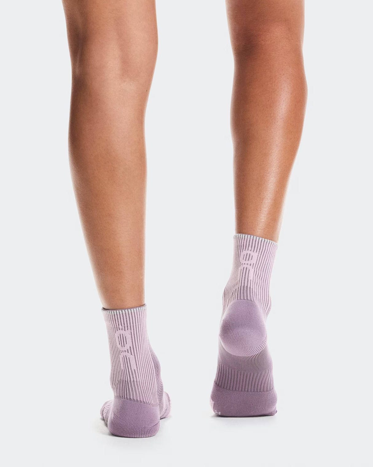 Person wearing light purple socks on a white background - On Performance Run Sock Mid (Unisex) - Dewberry/Sakura
