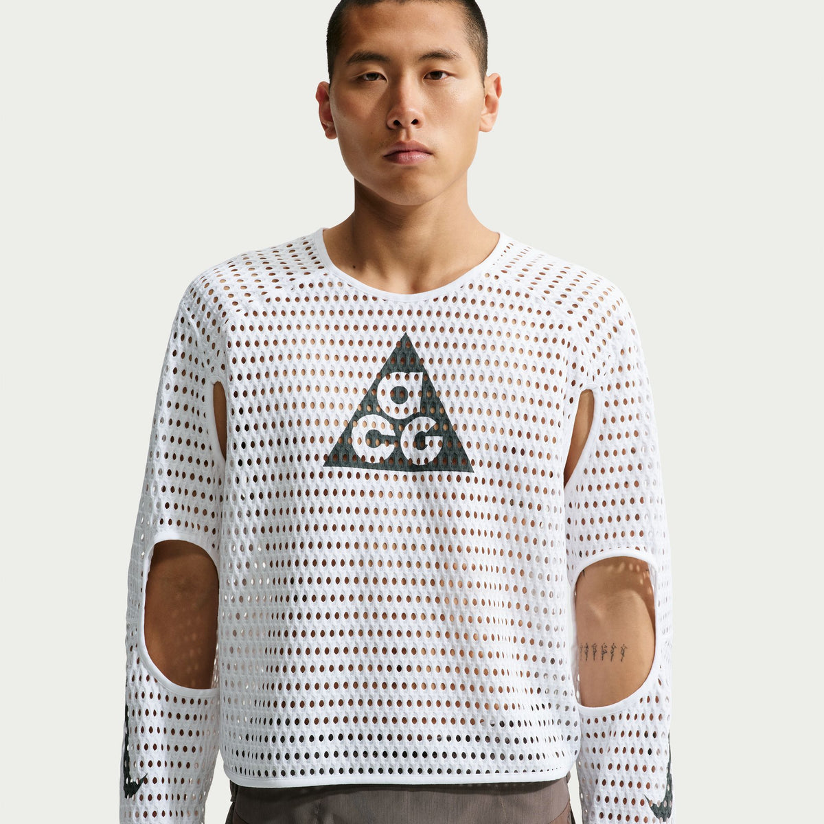 Man wearing a white long-sleeve shirt with a geometric pattern and logo on a plain background - Nike ACG Radical Airflow NXT Dri-FIT Long-Sleeve Trail-Running Top (Men's) - White/Anthracite