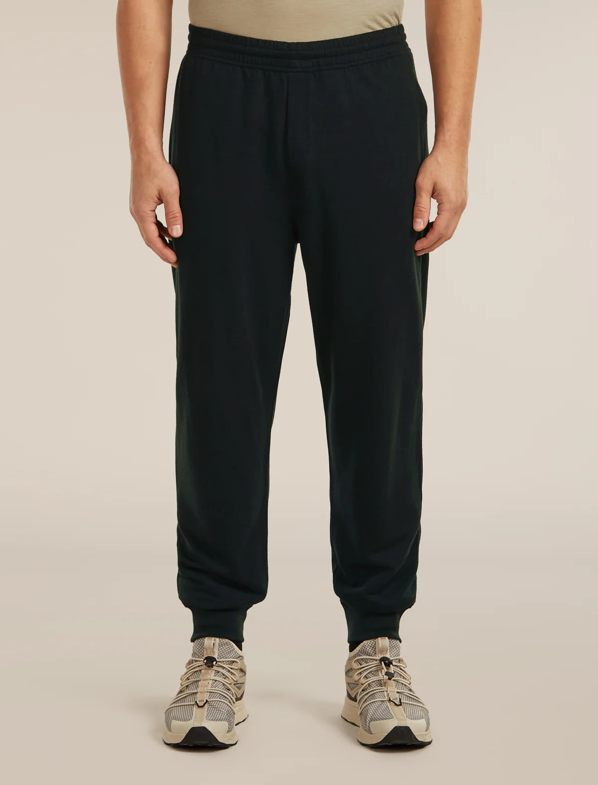 Person wearing black sweatpants on a beige background - Icebreaker Merino Blend 150 Drift Pants (Men's) - Black