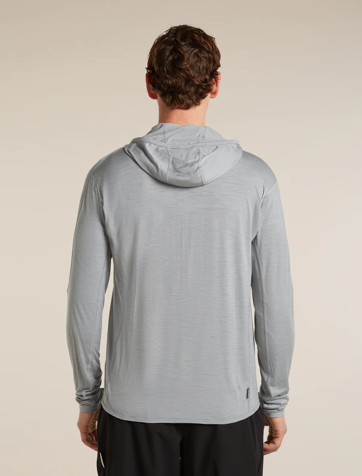 Man wearing a gray hooded jacket on a beige background - Icebreaker 150 MerinoFine Ace Long Sleeve Zip Hoodie (Men's) - Proto Grey