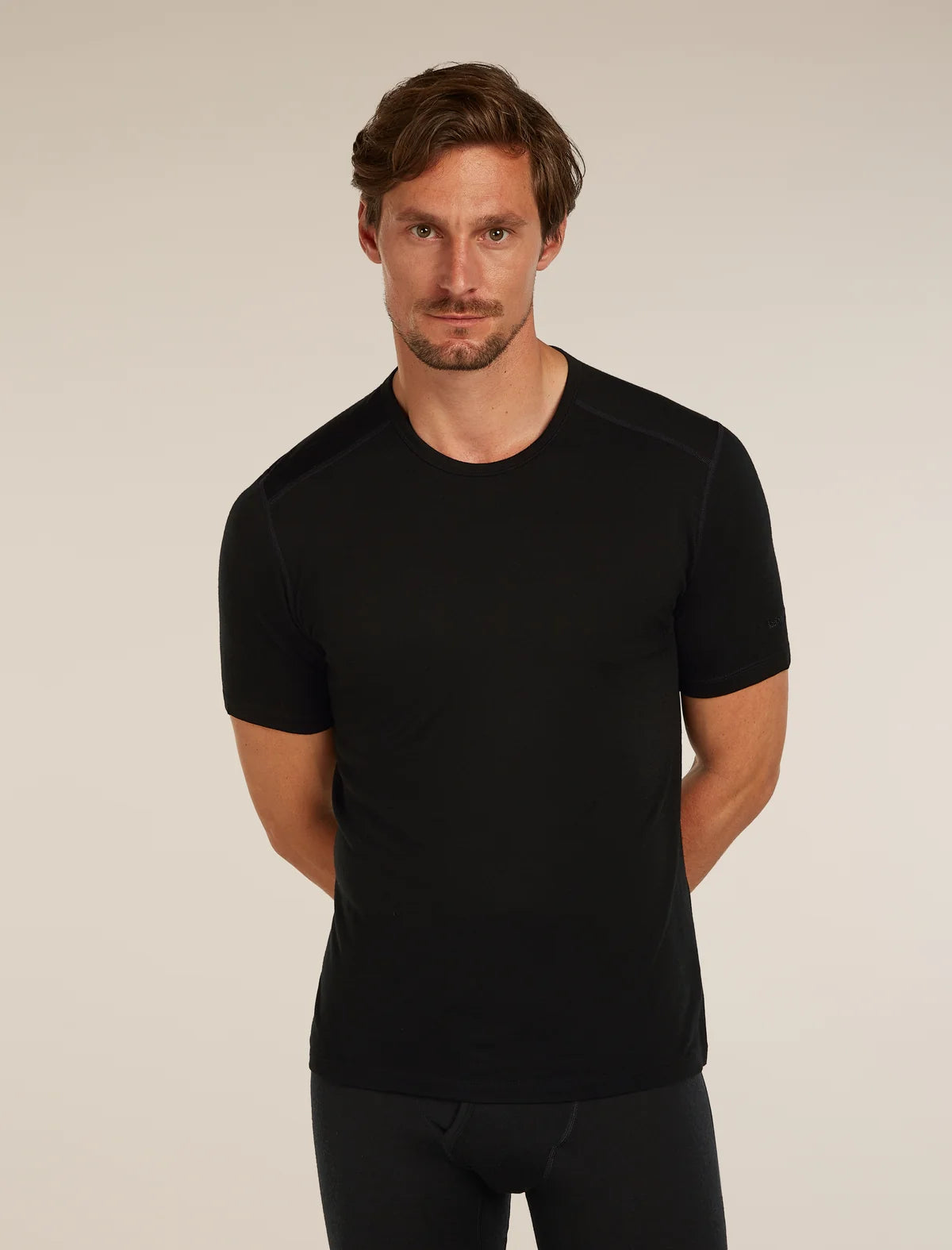 Man wearing a black t-shirt against a plain background - Icebreaker Merino 200 Oasis Short Sleeve Crew Neck (Men's) - Black