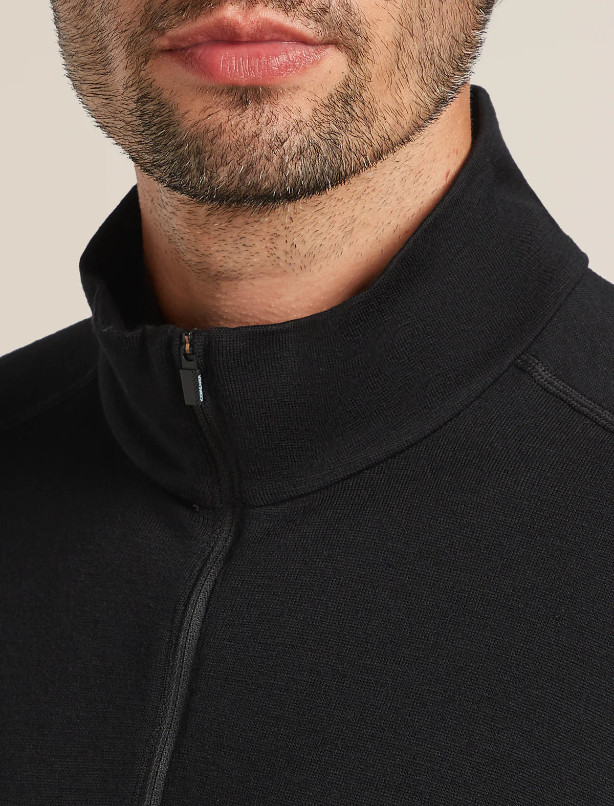 Close-up of a person wearing a black jacket with a zipper. - Icebreaker Merino 260 Tech Long Sleeve Half Zip (Men's) - Black