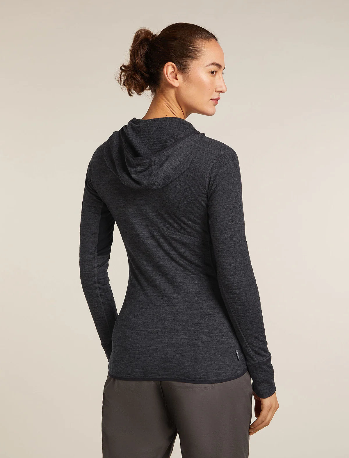 Woman wearing a dark gray hoodie and pants on a beige background - Icebreaker Merino Blend 200 Realfleece Descender Long Sleeve Zip Hoodie (Women's) - Jet Heather/Black