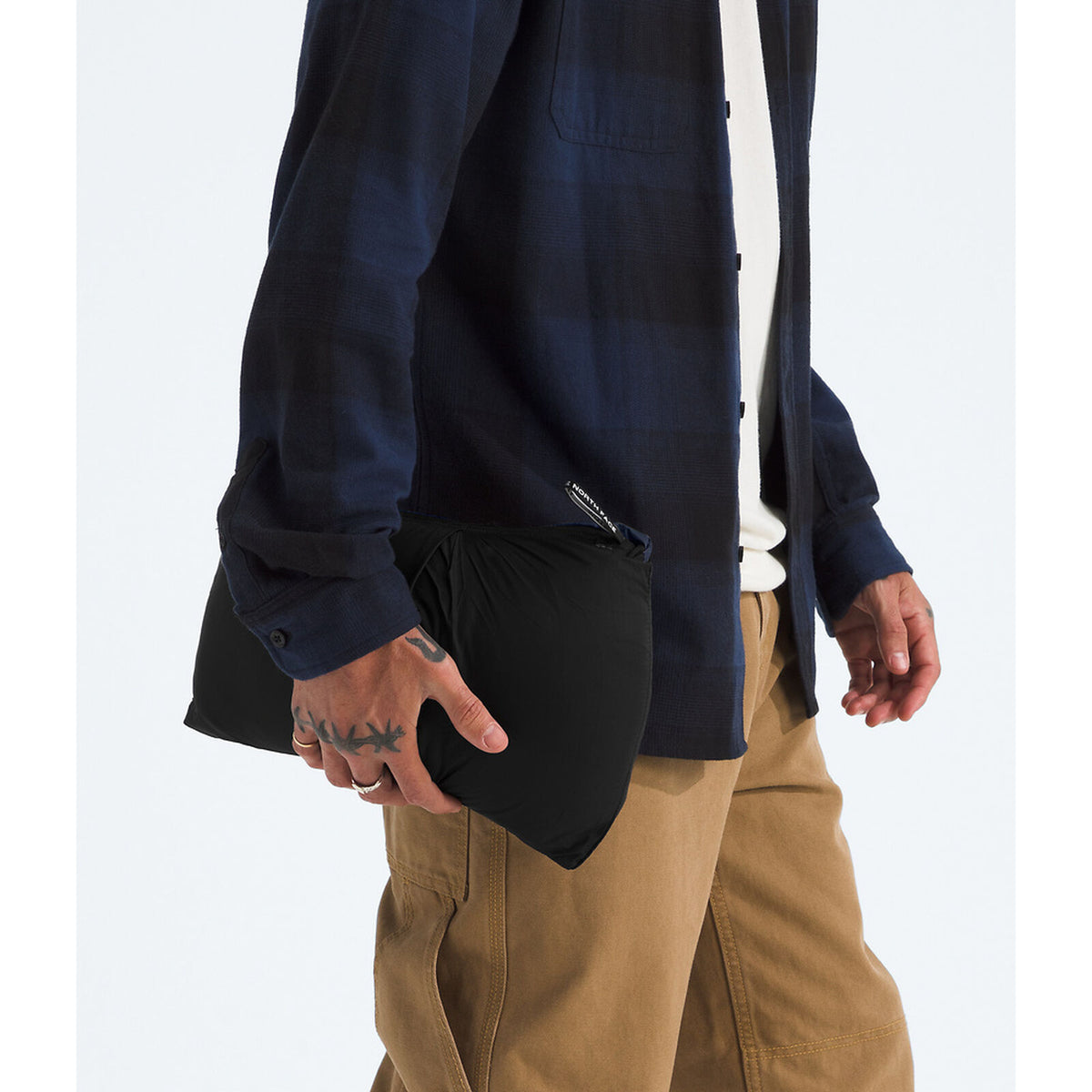 Person wearing a navy jacket over a black shirt with beige pants on a white background - The North Face 1996 Retro Nuptse Vest (Men's) - Summit Navy/TNF Black-Recycled Down