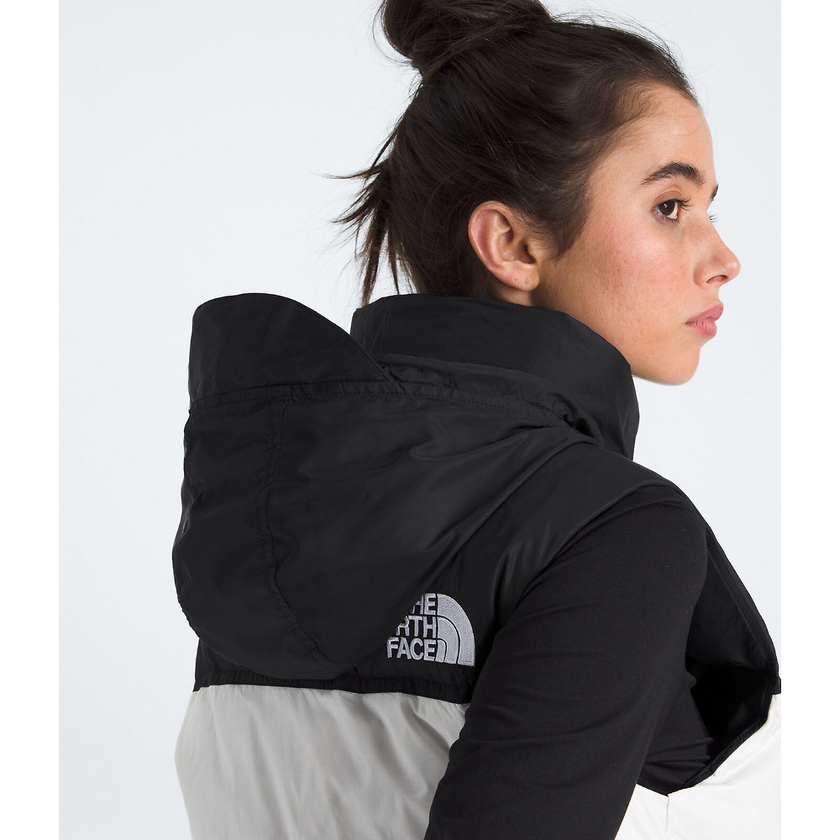 Woman wearing a black The North Face jacket on a white background - The North Face 1996 Retro Nuptse Vest (Womens) - White Dune/TNF Black-Recycled Down