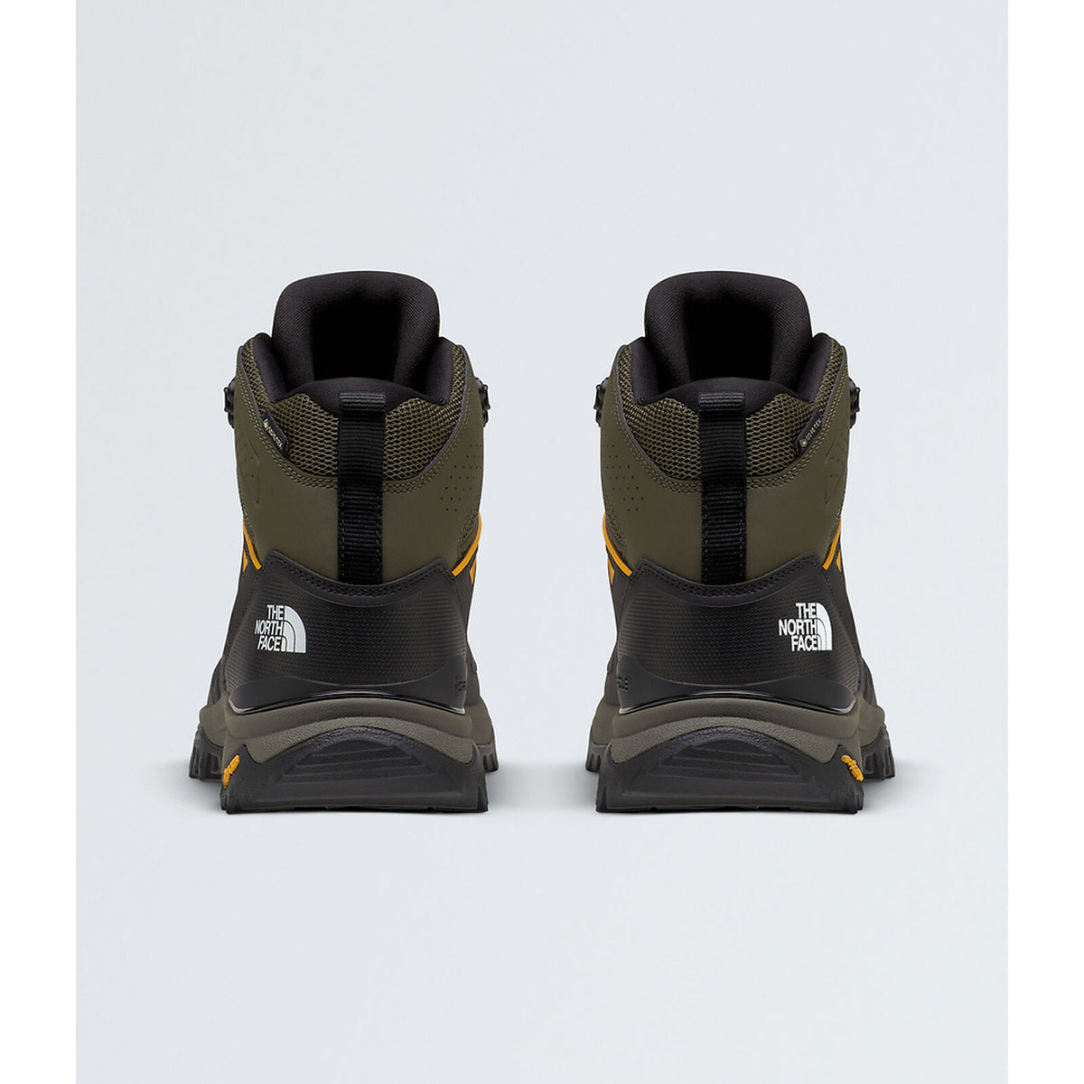 A pair of The North Face mid-height hiking boots shown from the back, featuring an olive green and black design with small yellow accents and white logo branding. - The North Face Hedgehog Mid GORE-TEX Boots (Men's) - New Taupe Green/TNF Black