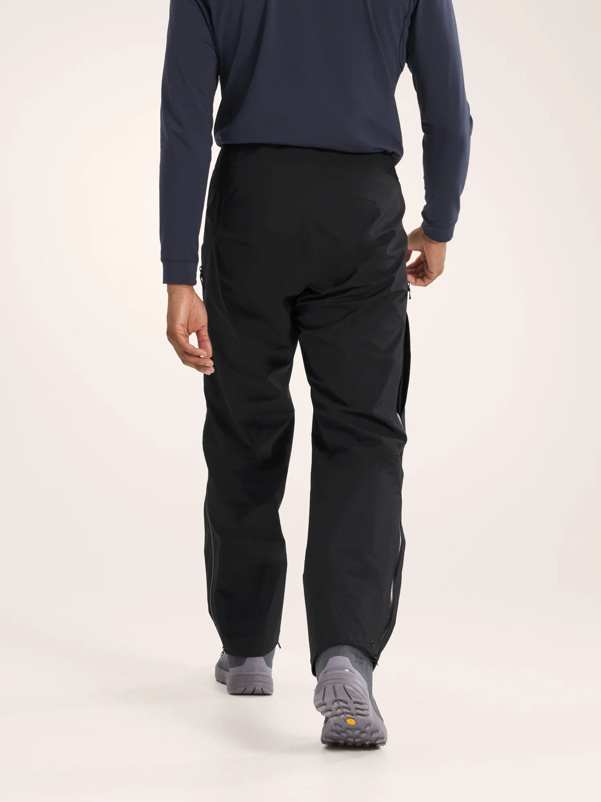 Person wearing black pants and a blue long-sleeve shirt on a white background - Arc'teryx Beta Pants (Men's) - Black