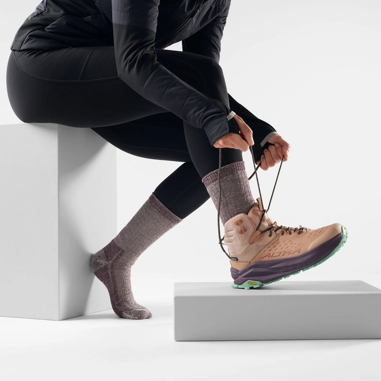 Person tying shoelaces on a hiking boot with socks on a white background - Smartwool Hike Classic Edition Full Cushion Crew Socks (Women's) - Bordeaux
