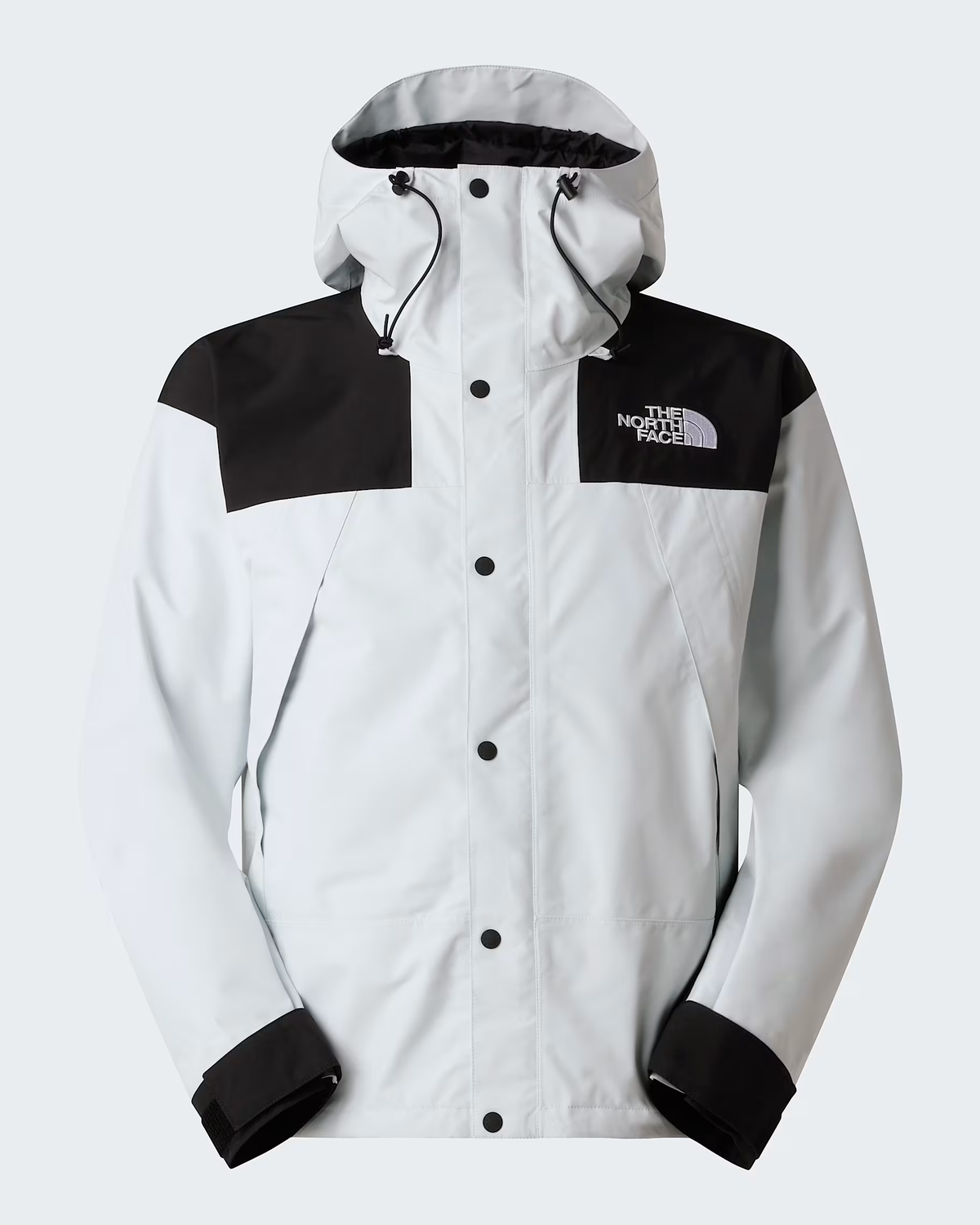 A light gray and black hooded jacket by The North Face, featuring a snap-button front, black shoulder panels, and black cuff trims, shown against a light gray background. - The North Face GORE-TEX Mountain Jacket (Men's) - Pearl Stone/TNF Black