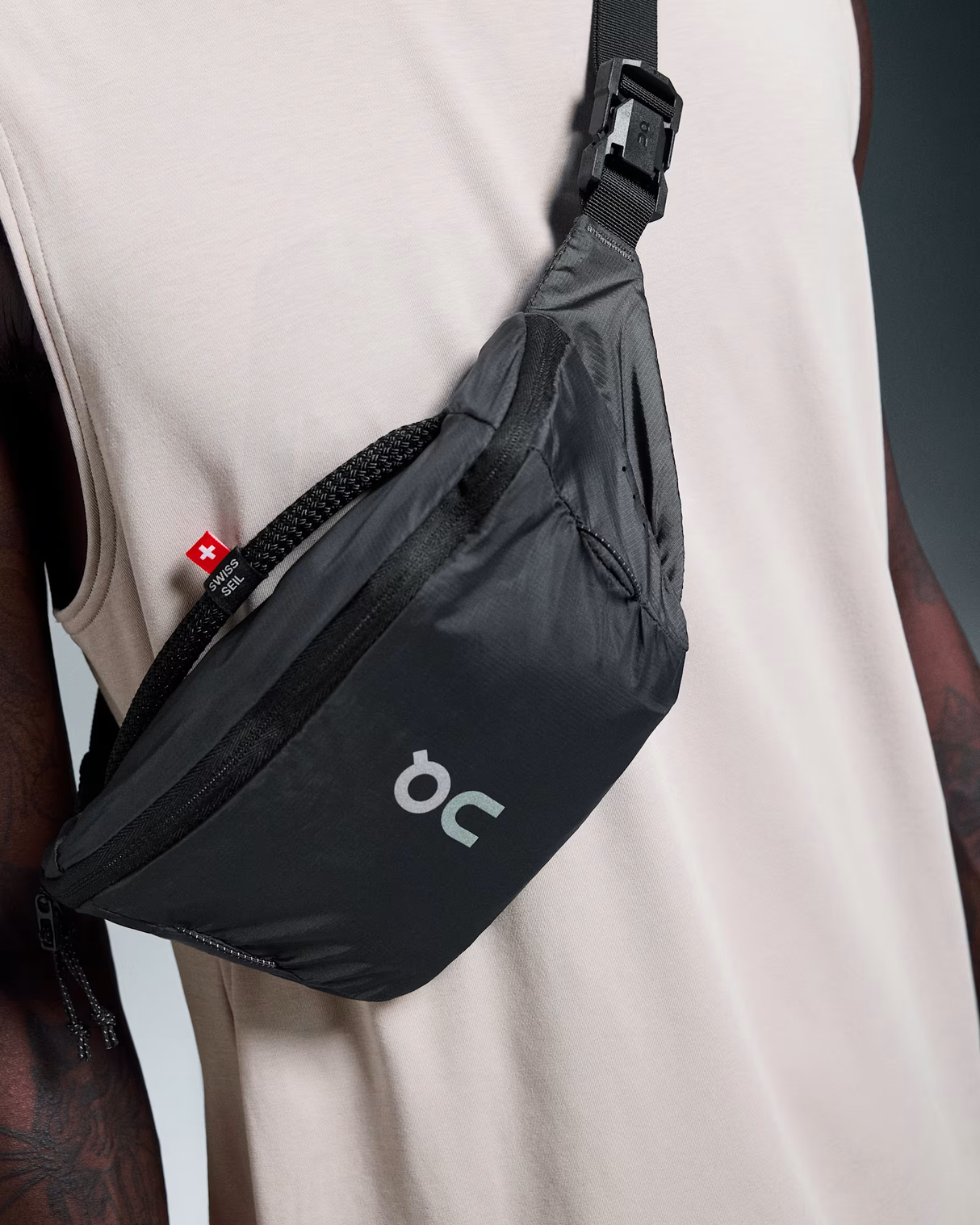 Black waist bag with a visible brand logo worn by a person against a neutral background - On Waist Pack 2L Lite - Magnet