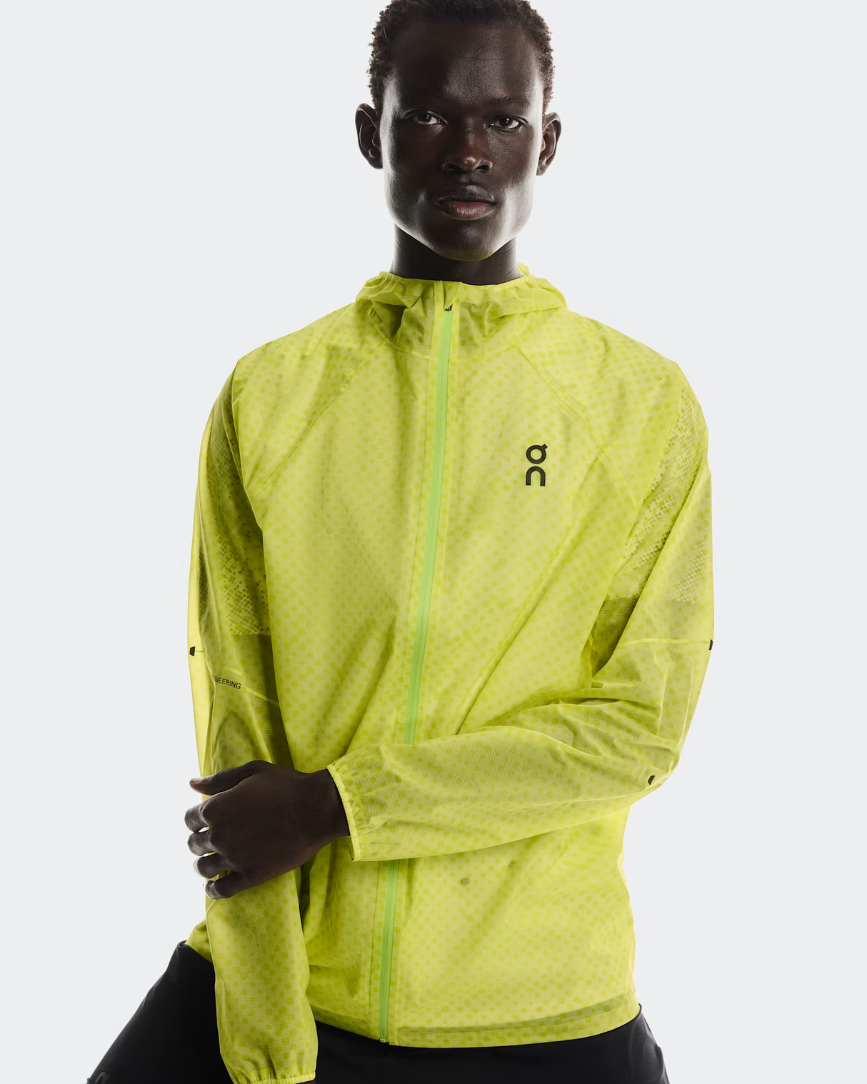 Person wearing a bright green jacket with a brand logo on a white background - On Ultra Jacket (Men's) - Limelight/Lime