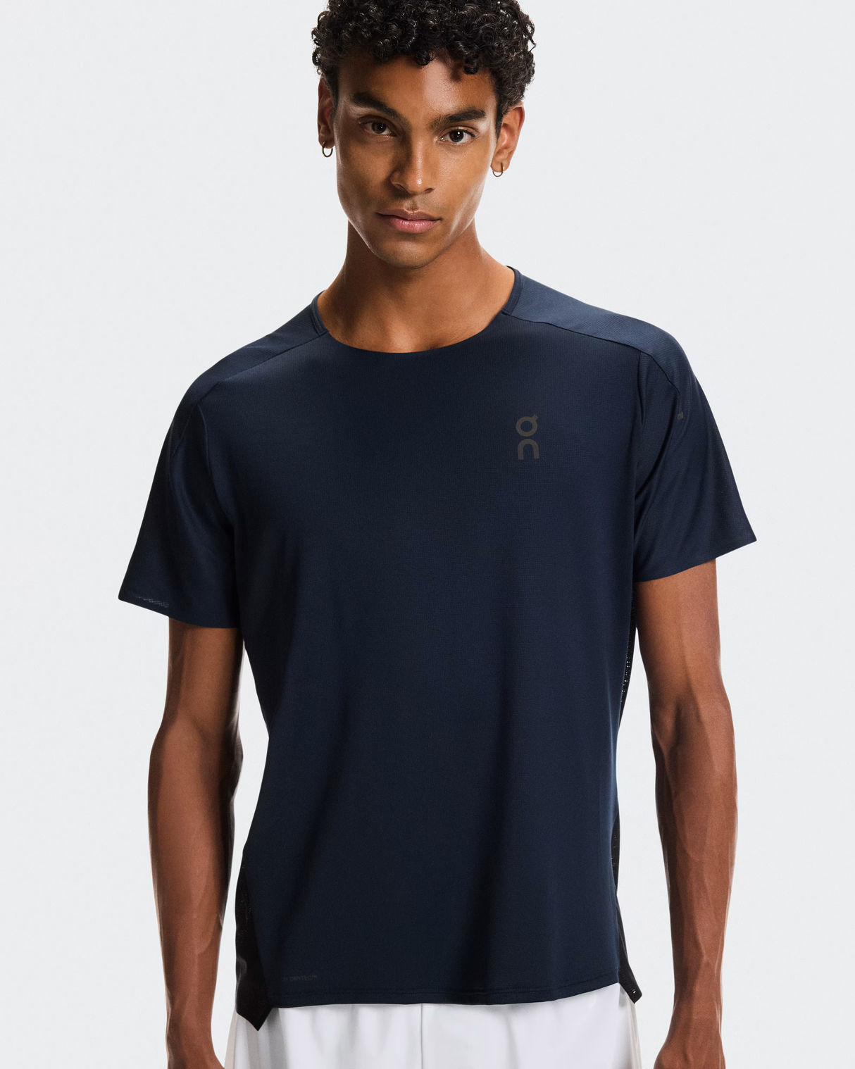 Man wearing a navy blue t-shirt with a brand logo on a white background - On Performance-T (Men's) - Navy/Black