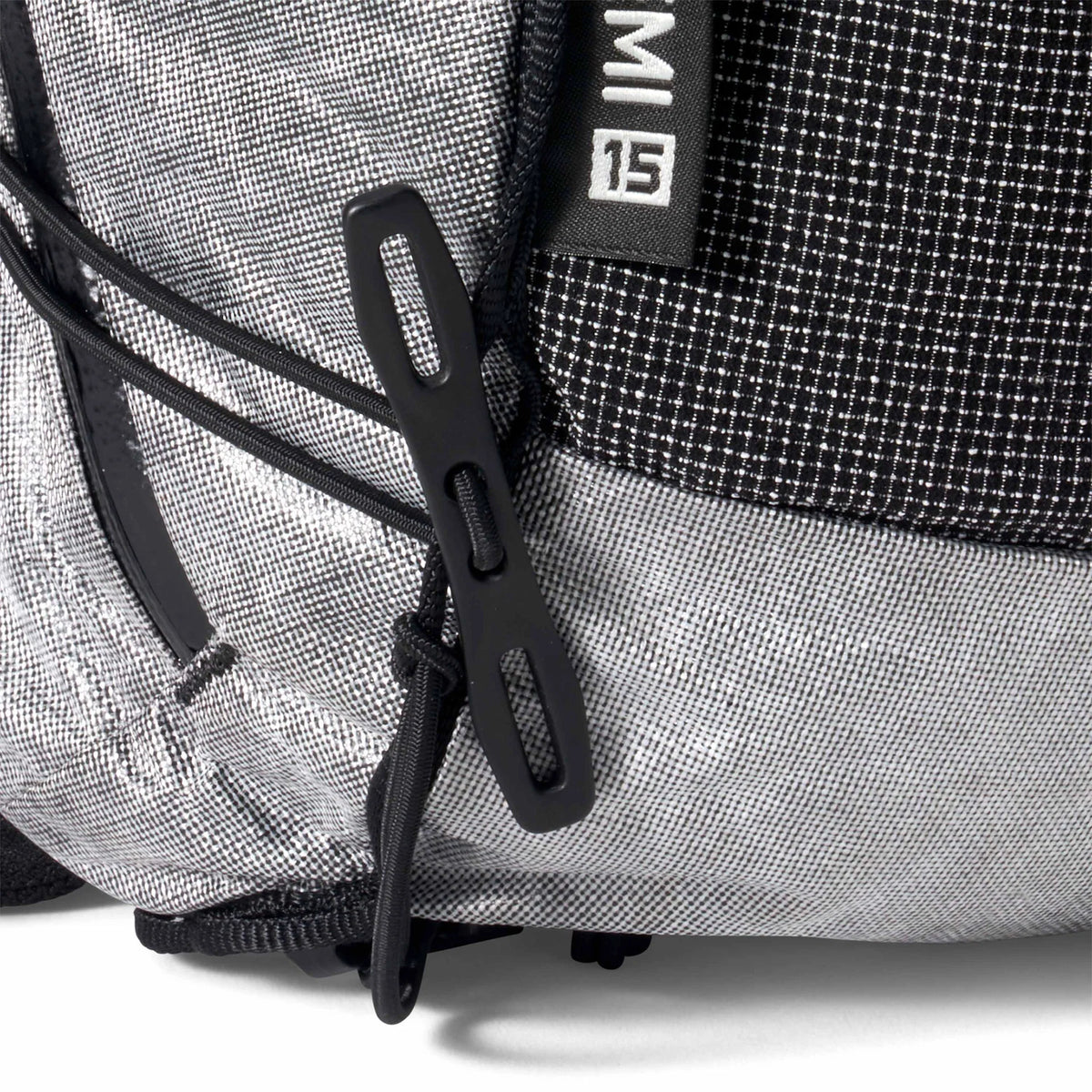 Close-up of a gray backpack with black straps and a brand logo on a white background - Hyperlite Mountain Gear Pemi 15 Backpack
