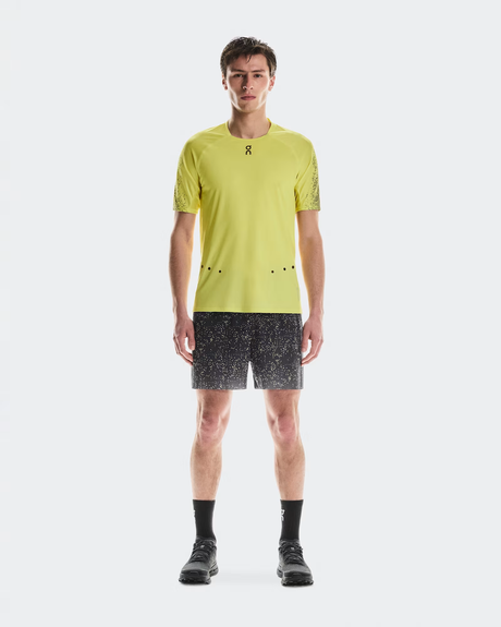 Person wearing a yellow athletic shirt and black shorts on a white background - On Ultra Shorts (Men's) - Iron/Lime