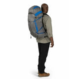 Person wearing a large gray backpack with blue accents on a white background - Osprey Exos Pro 55 Backpack (Men's) - Dale Grey/Agam Blue