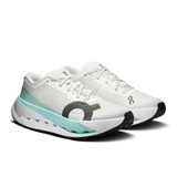 A pair of white running shoes with a light blue and gray accent design, featuring the 'ooc' logo on the side and tongue, set against a plain white background. - On Cloudultra Pro Shoes (Women's) - Ivory/Celeste