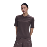 A woman modeling a short-sleeve athletic top in a dark brownish-gray color, paired with matching patterned shorts, against a solid white background. - On Trail-T Solar (Women's) - Mulberry
