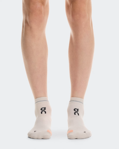 Person wearing light gray socks with a logo on a white background - On Performance Run Sock Low (Unisex) - Pearl/Sunstone
