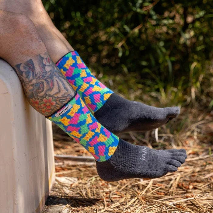 Person wearing colorful patterned socks with black toe socks outdoors. - Injinji Spectrum Trail Midweight Crew Socks (Unisex) - Gummy Bears