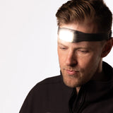 Man wearing a headlamp on a white background - Biolite Range 500 Headlamp - Midnight Grey