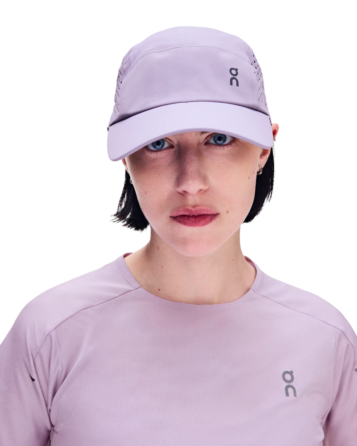 A woman wearing a light purple On running cap and a matching light purple On long-sleeve athletic top, shown from the chest up against a plain white background. - On Lightweight Cap - Mallow