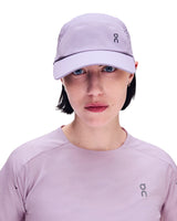 A woman wearing a light purple On running cap and a matching light purple On long-sleeve athletic top, shown from the chest up against a plain white background. - On Lightweight Cap - Mallow
