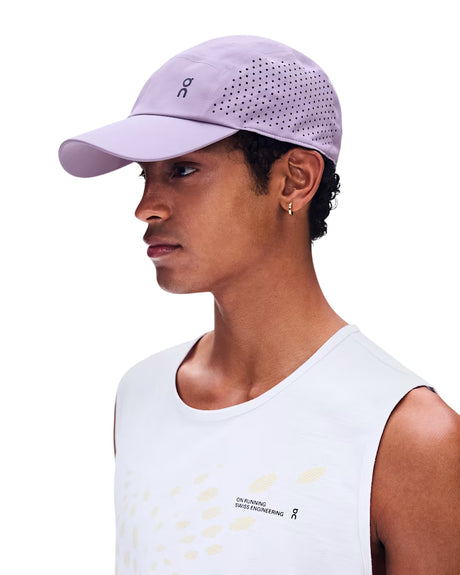 A man in profile wearing a light purple athletic cap with a perforated back panel and a white sleeveless top, photographed against a plain white background. - On Lightweight Cap - Mallow