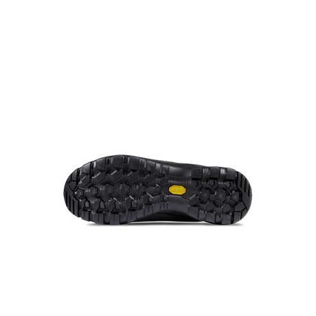 The black rubber outsole of a shoe, showing deep tread patterns and a small yellow Vibram logo on the heel, photographed against a solid white background. - Mammut Mercury Tour II High GORE-TEX (Men's) - Black/Black