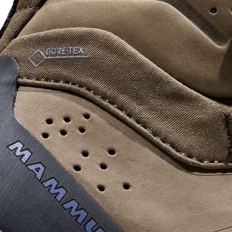 Close-up detail of a brown Mammut boot showing the Mammut logo on a dark gray panel and a stitched GORE-TEX label on the suede upper. - Mammut Nova Tour II High GORE-TEX Boots (Women's) - Oak/Bark