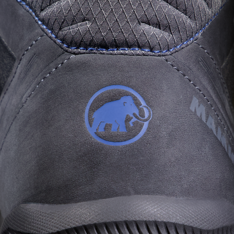 Close-up of a dark gray suede shoe with a blue Mammut logo on the heel, showing textured stitching and the brand name partially visible. - Mammut Mercury IV Mid GORE-TEX (Men's) - Dark Titanium/Black