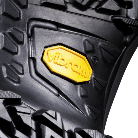 Close-up of a black textured rubber surface with a yellow Vibram logo badge in the center. - Mammut Mercury IV Mid GORE-TEX (Men's) - Dark Titanium/Black