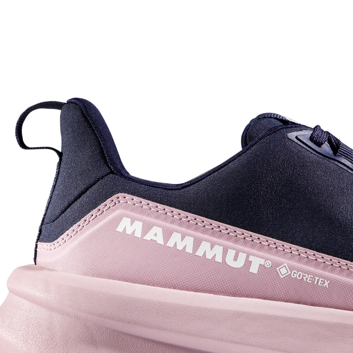 Close-up of a Mammut sneaker showing the heel and side profile, featuring a dark navy blue upper, a light pink midsole section with white Mammut and GORE-TEX branding, and a pale pink sole on a white background. - Mammut Aenergy Hike Low GORE-TEX Shoes (Women's) - Marine/Dark Alpine Calamint