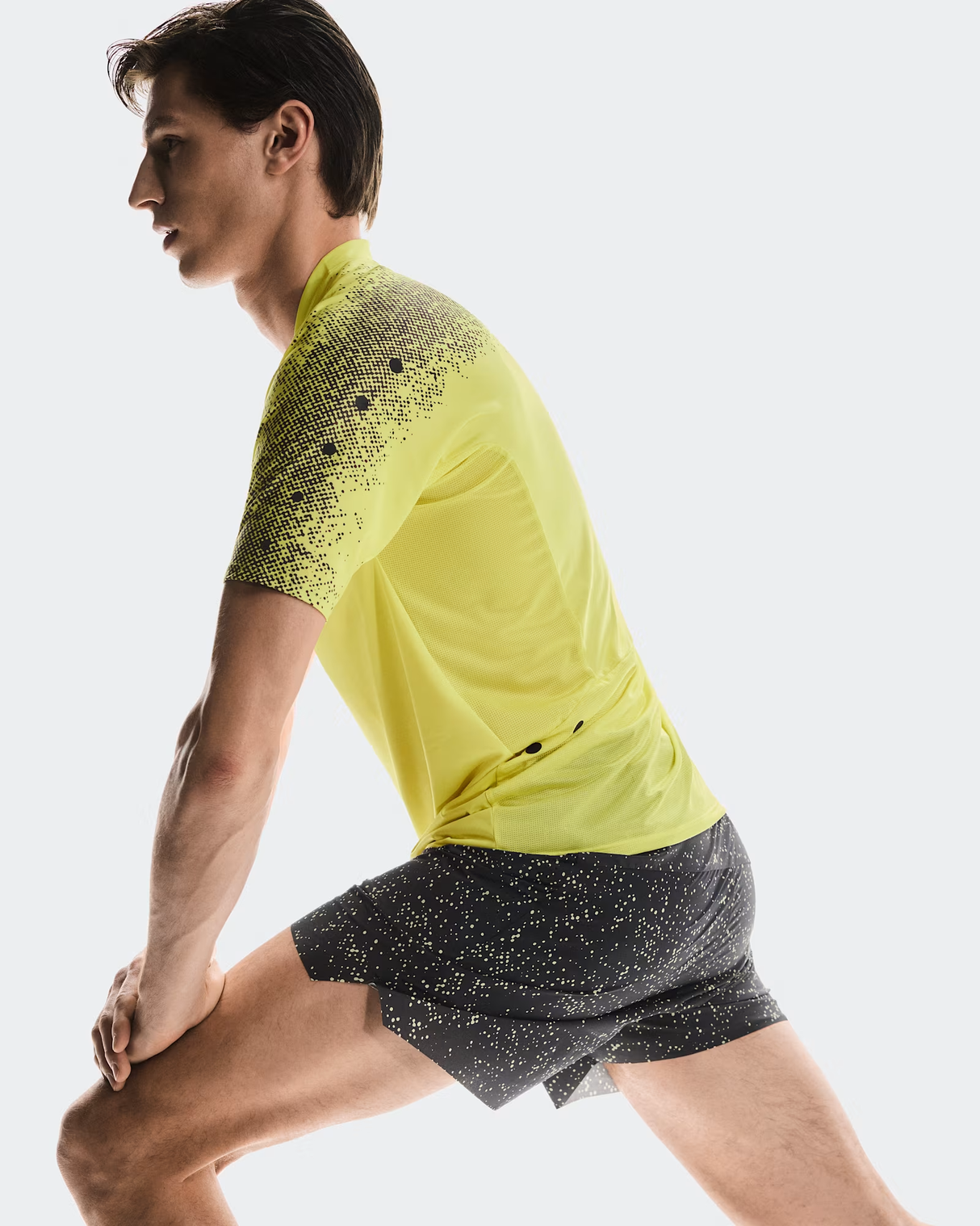 Person wearing a yellow and black athletic outfit on a light gray background - On Ultra Shorts (Men's) - Iron/Lime