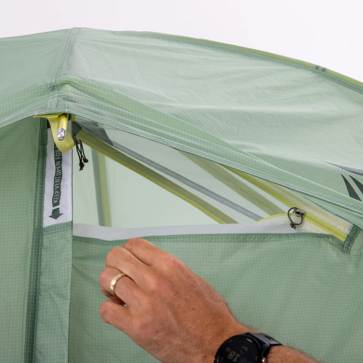 Person adjusting a green tent with a clear window, showing a close-up of the zipper. - Sea to Summit Sentinel Tent
