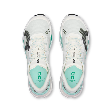 A pair of On running shoes shown from a top-down view, featuring a white mesh upper with mint green accents and black logo details. - On Cloudultra Pro Shoes (Men's) - Ivory/Celeste