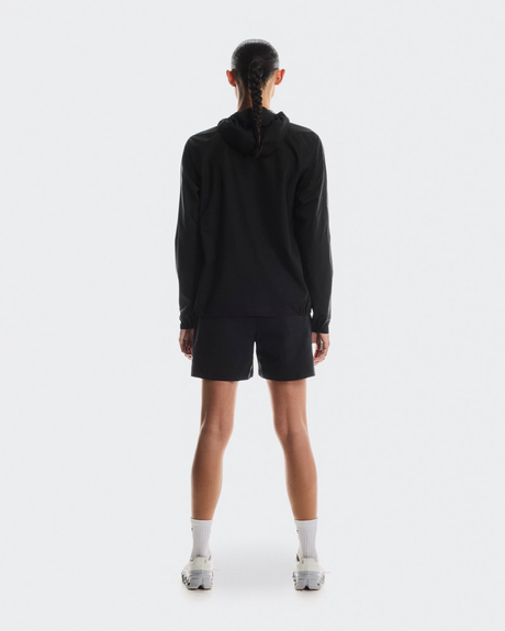 Person wearing a black hoodie and shorts on a white background - On Performance Jacket (Women's) - Black