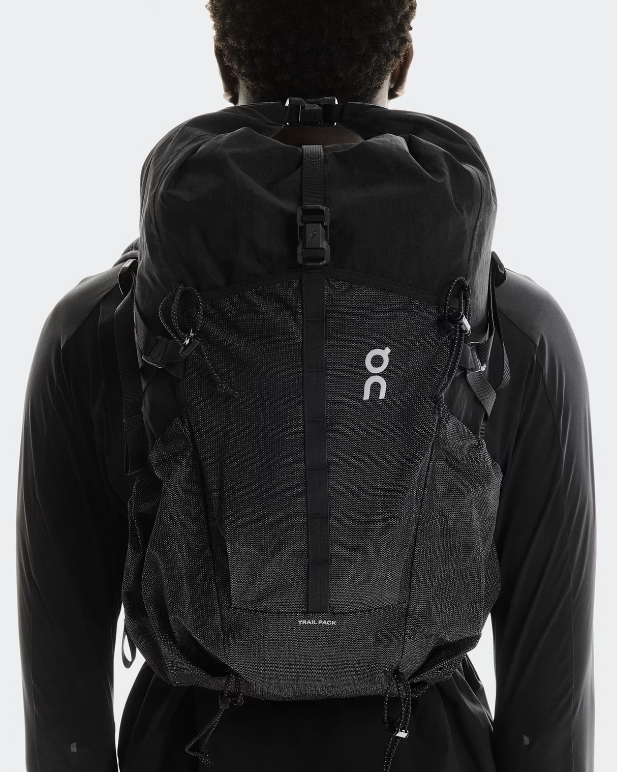Person wearing a black backpack with a visible brand logo on a white background - On Trail Pack 20L - Black