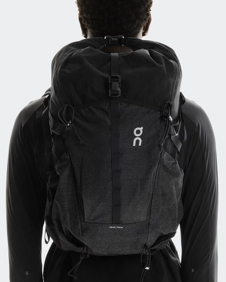 Person wearing a black backpack with a visible brand logo on a white background - On Trail Pack 20L - Black