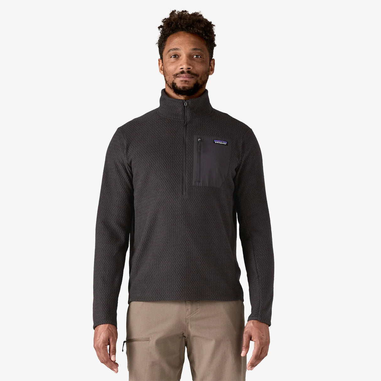 Man wearing a black long-sleeve shirt with a textured pattern on a white background - Patagonia R1 Air Fleece Zip-Neck (Men's) - Black