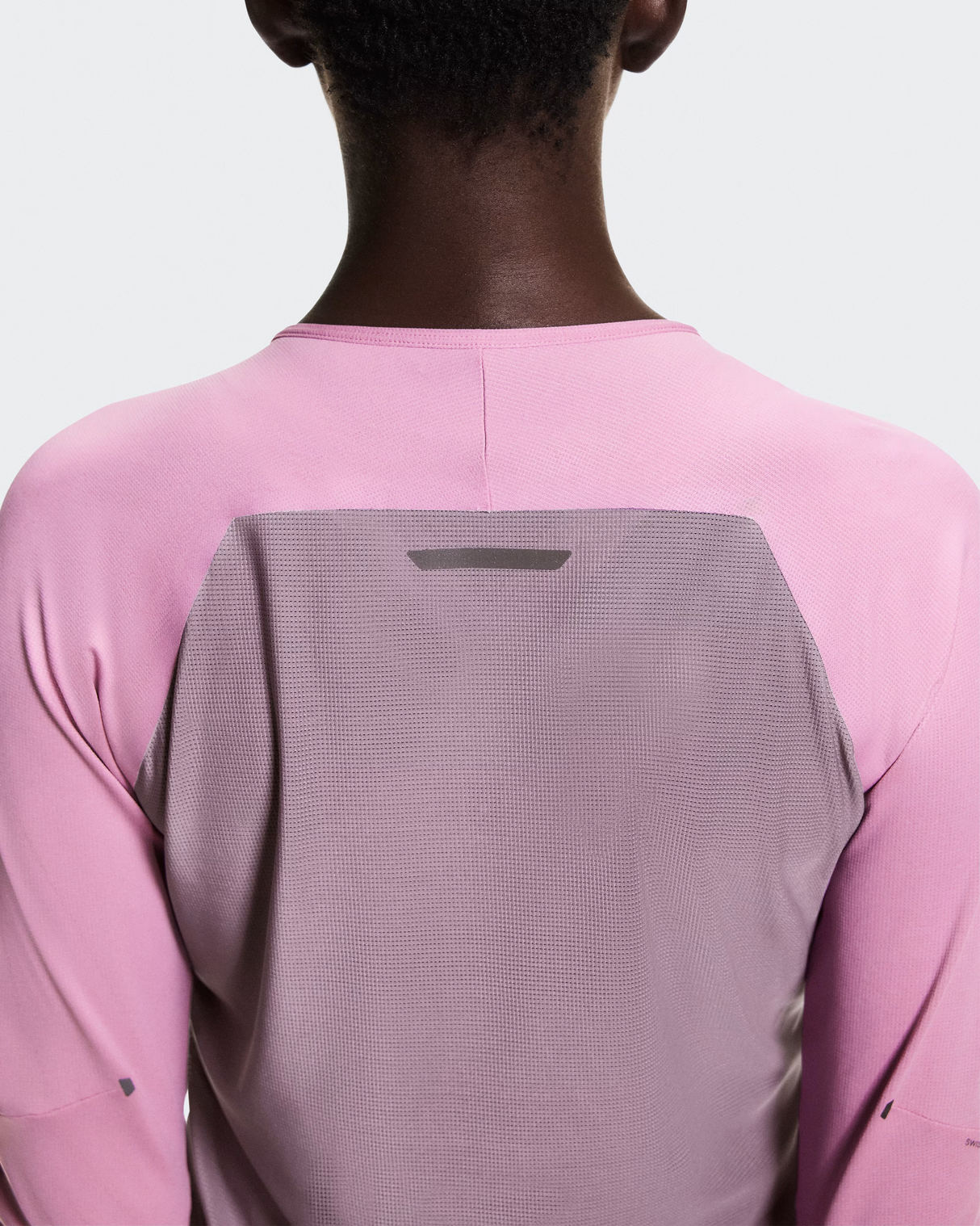 Person wearing a pink and gray long-sleeve shirt with a white background - On Performance Long-T (Women's) - Dewberry/Sakura