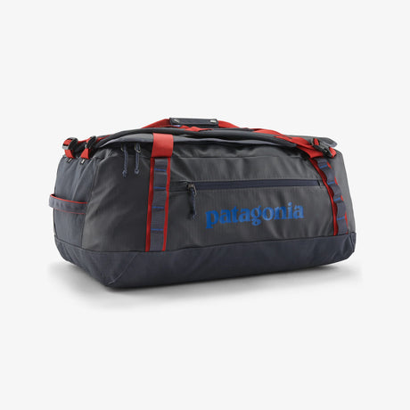 Gray duffel bag with red accents and Patagonia logo on a white background - Patagonia Black Hole Duffel 55L - Smolder Blue w/Amanita Red