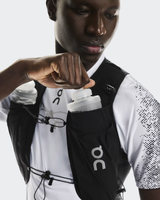Person wearing a black On running vest with a white shirt underneath on a light gray background - On Ultra Vest Pro (Unisex) - Black